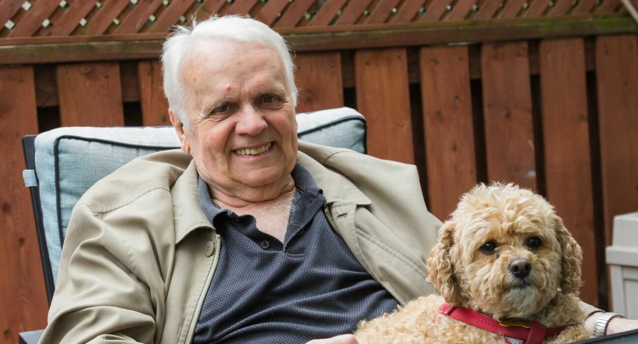 Starszy mężczyzna spacerujący z psem w parku