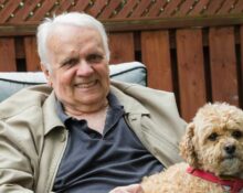 Starszy mężczyzna spacerujący z psem w parku