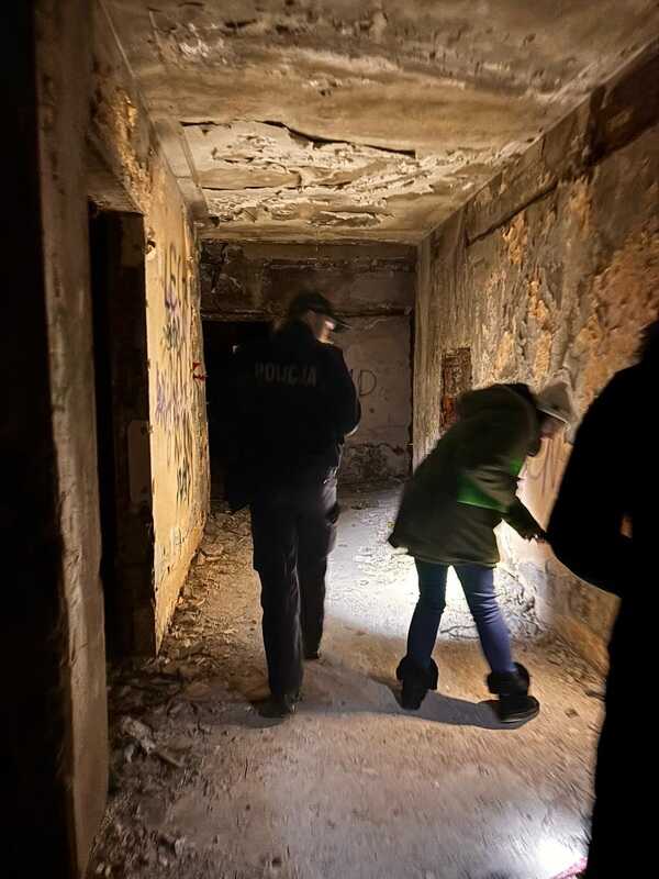 Policjanci i pracownicy socjalni rozmawiają z osobą w kryzysie bezdomności podczas interwencji pomocowej