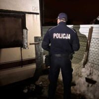 Policjant kontrolujący prowizoryczne miejsce schronienia podczas zimowego patrolu w Redzie