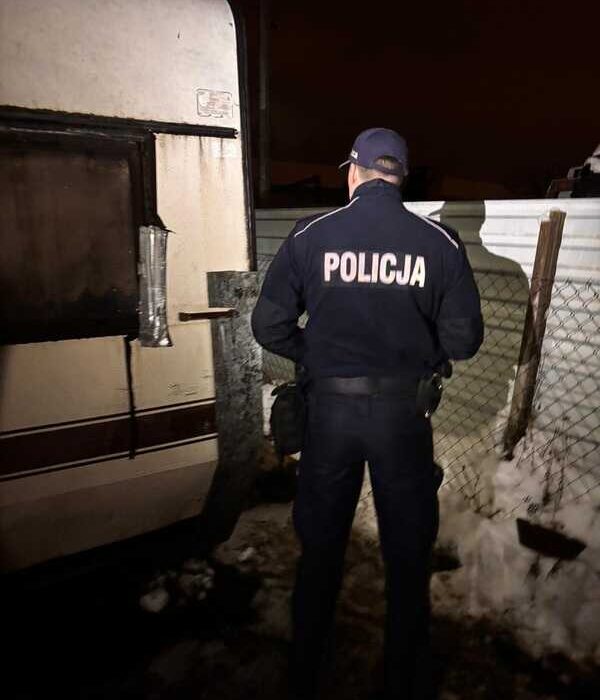 Policjant kontrolujący prowizoryczne miejsce schronienia podczas zimowego patrolu w Redzie