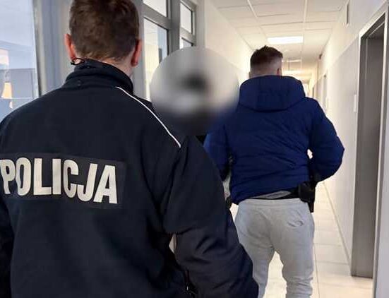 Policjanci prowadzą nieletnią osobę korytarzem budynku służbowego – zdjęcie ilustracyjne