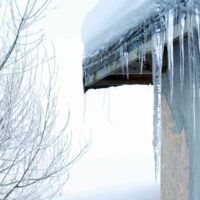 Sople lodu zwisające z krawędzi dachu – zimowe zagrożenie dla przechodniów