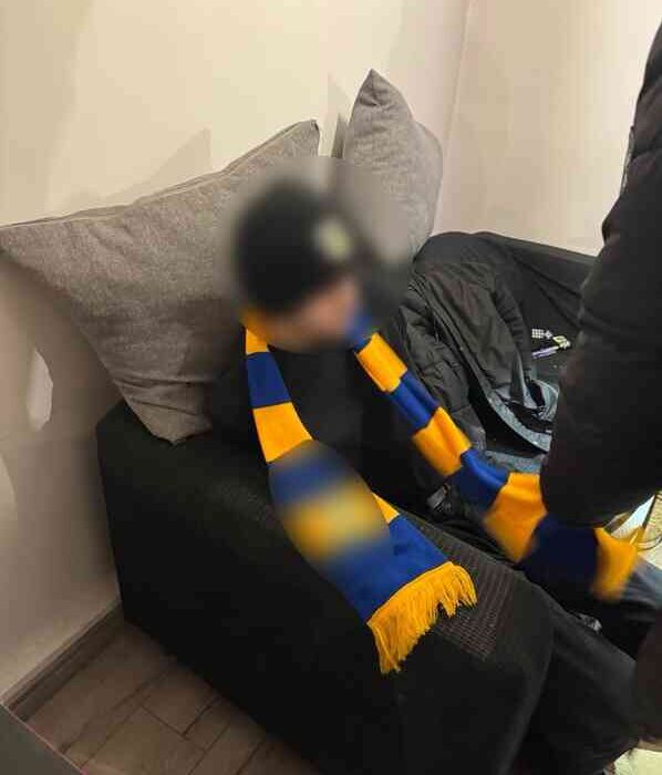 Zatrzymana osoba z klubowym szalikiem – elementy identyfikujące środowisko pseudokibiców (twarz zamazana)