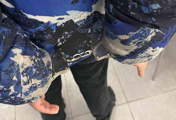 Kajdanki na rękach zatrzymanej osoby – czynności policyjne po zdarzeniu (twarz niewidoczna)