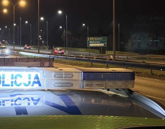 Policyjny radiowóz z włączoną belką świetlną „POLICJA” na tle nocnej drogi w okolicach Wejherowa