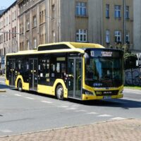 Żółty autobus miejski MAN Lion's City numer 840 PKM Katowice na linii 10 w kierunku Sądowej, jadący przez skrzyżowanie w centrum Katowic.