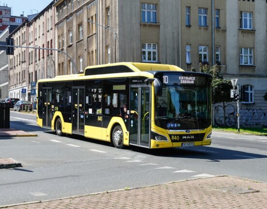 Żółty autobus miejski MAN Lion's City numer 840 PKM Katowice na linii 10 w kierunku Sądowej, jadący przez skrzyżowanie w centrum Katowic.