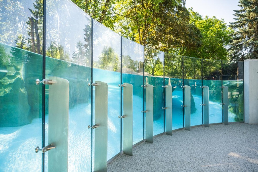 Przeszklona ściana basenu przy nowym wybiegu pingwinów przylądkowych w Warszawskim ZOO — panoramiczne szyby umożliwiające obserwację pływających pingwinów pod wodą